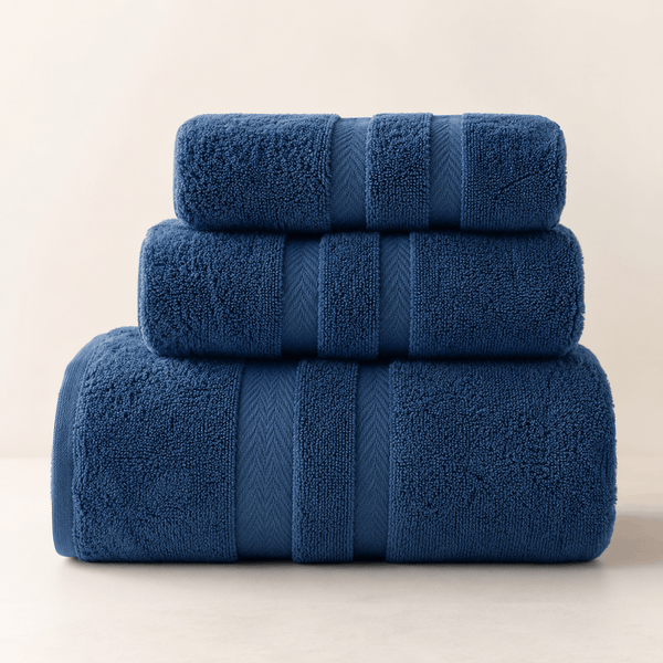 Aarniva 100% cotton towel set in deep blue, featuring three soft, absorbent, and lint-free towels stacked.