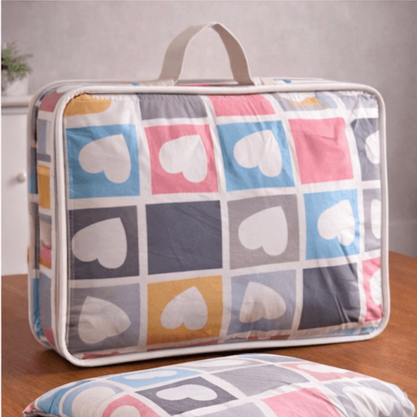 Aarniva breathable heart pattern comforter set packaging with vibrant heart design on a wooden table.