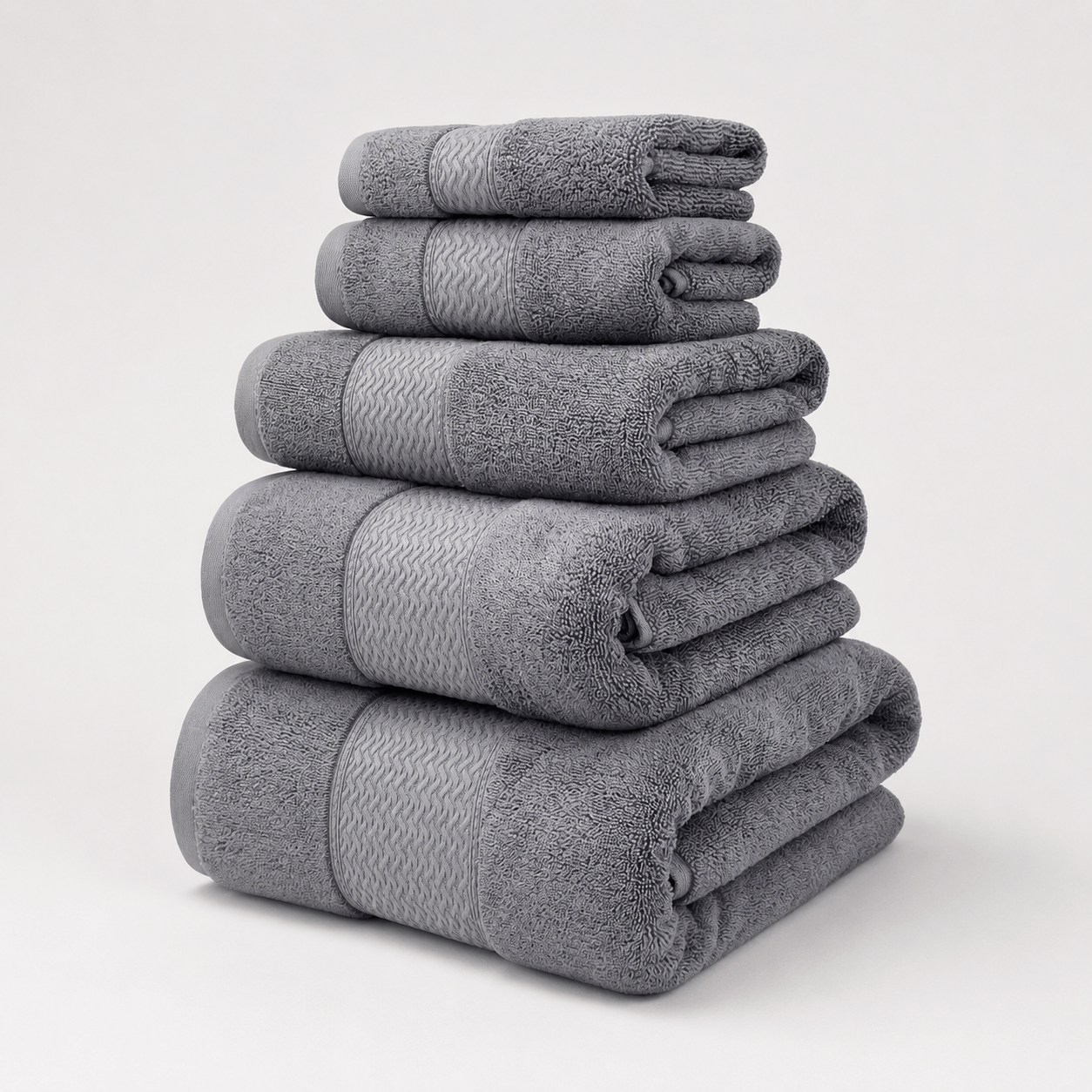 Aarniva cotton jacquard towel set in grey, featuring a soft and absorbent 5-piece towel collection stacked for everyday use.
