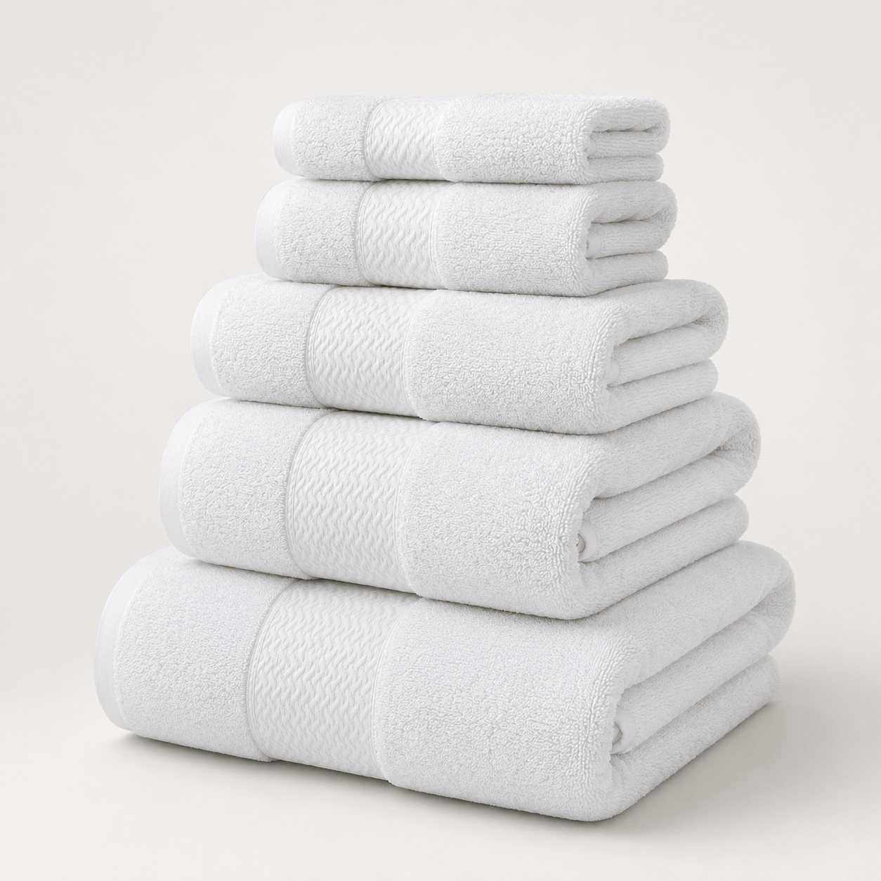 Aarniva cotton jacquard towel set in white, featuring five soft, thick, and absorbent towels stacked neatly.