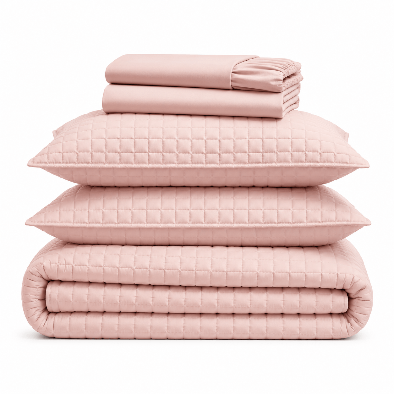 Aarniva blush pink quilted bedding set stacked with pillows and blanket on top.