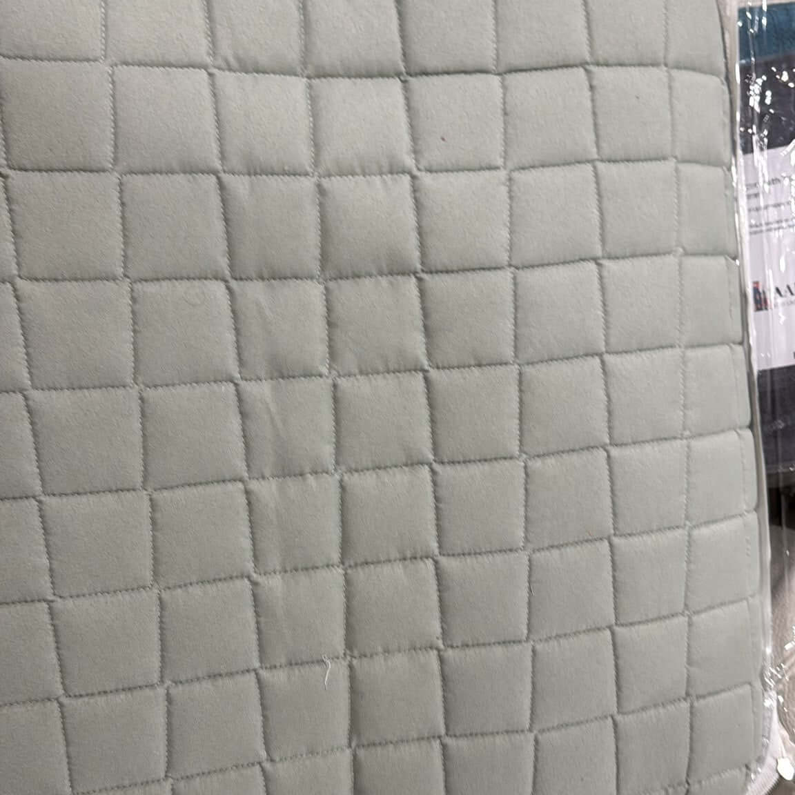 Close-up of the Aarniva quilted bedding set in stone taupe with stitched grid texture.