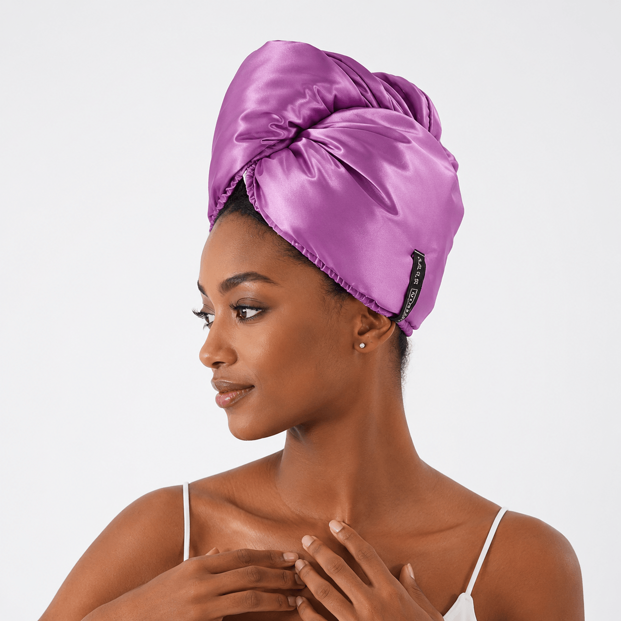 Aarniva satin microfiber hair drying turban in bright purple worn by a woman for comfortable hair drying.