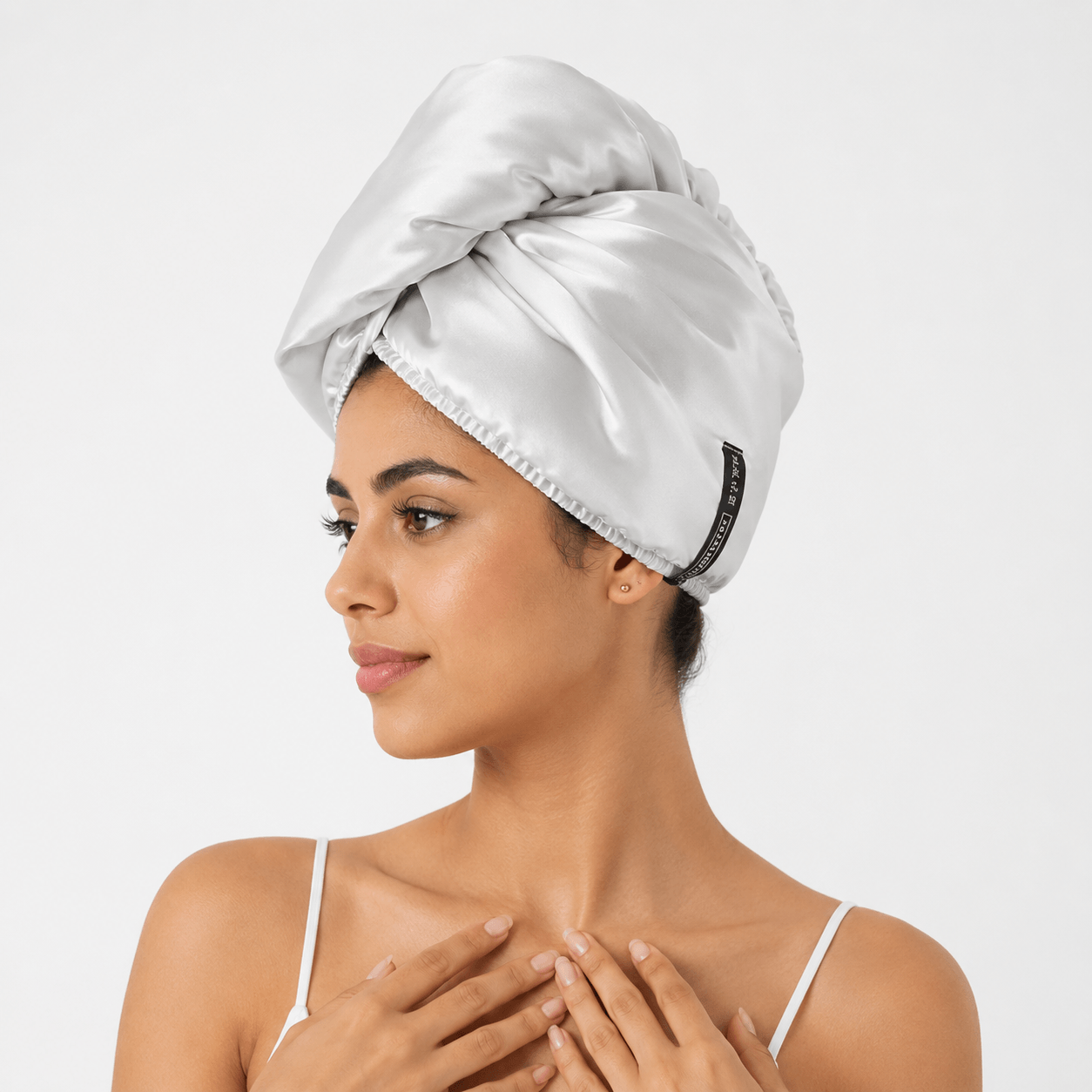 Aarniva satin microfiber hair drying turban in bright silver worn by a woman, providing a smooth and comfortable drying experience.