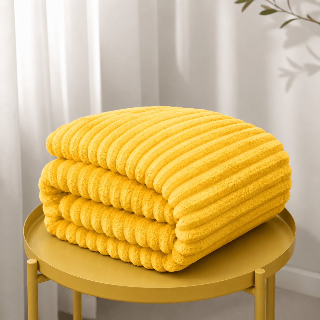 soft flannel throw blanket in sunshine yellow neatly folded on a round table, showcasing its ribbed texture and cozy design.