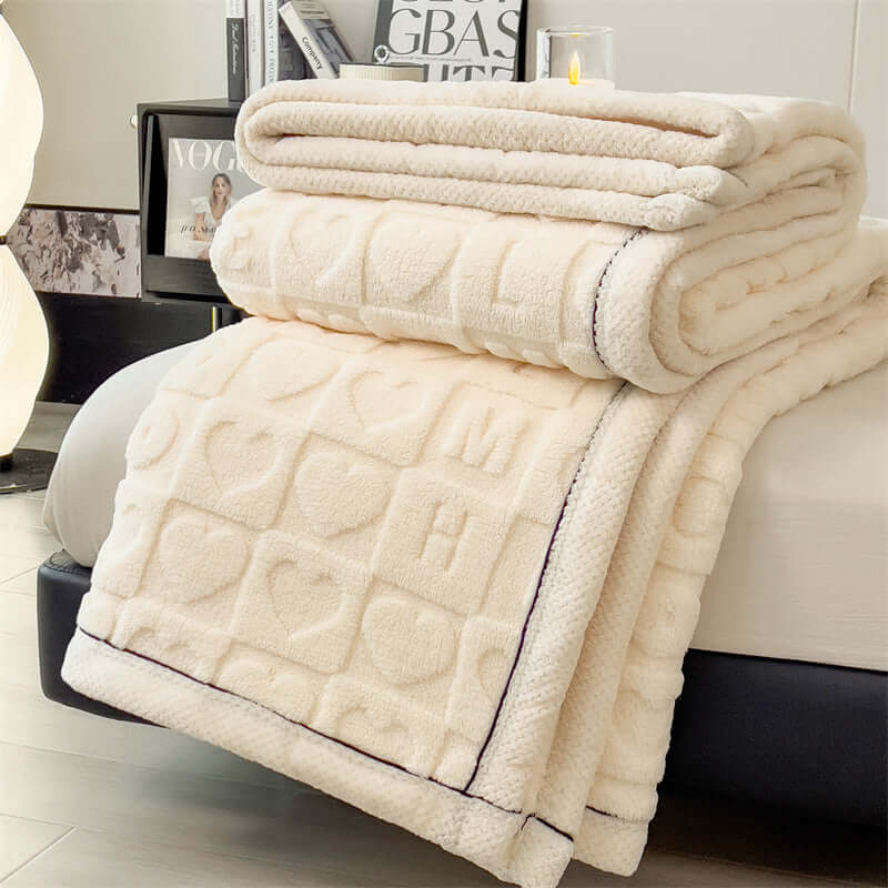 New Love Taffu multifunctional coral fleece blanket in white, elegantly displayed folded on a bed.